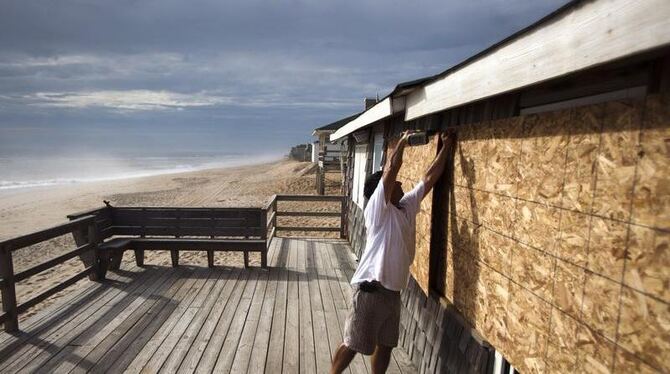 Angst vor dem Sturm: Ein US-Amerikaner schraubt Spanplatten an sein Haus.