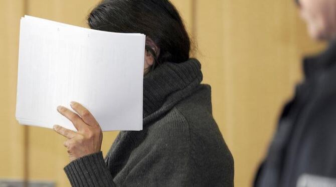 Die wegen Totschlags angeklagte 36-Jährige verdeckt am 24.10.2011 vor dem Landgericht in Braunschweig ihr Gesicht. Foto: Holg