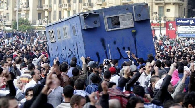 Demonstranten haben in Kairo einen Wagen der Polizei eingekreist.