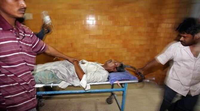 Ein Opfer des vergifteten Alkohols wird ins Krankenhaus gebracht. Foto: Piyal Adhikary