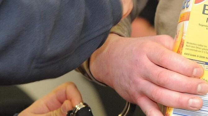 Ein Justizbeamter nimmt  dem Angeklagten im Landgericht Potsdam die Handschellen ab. Foto: Bernd Settnik 