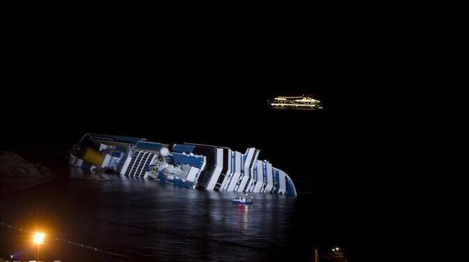 Die »Costa Serena« fährt an ihrem havarierten Schwesterschiff »Costa Concordia« vorbei. Foto: Massimo Percossi