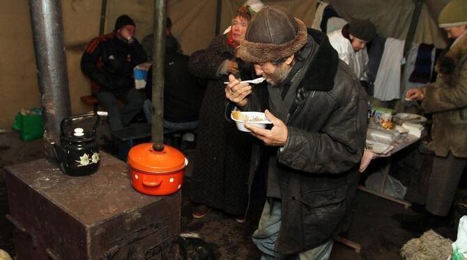 Ukrainische Obdachlose wärmen sich in ein Zelt. Foto: Photomig