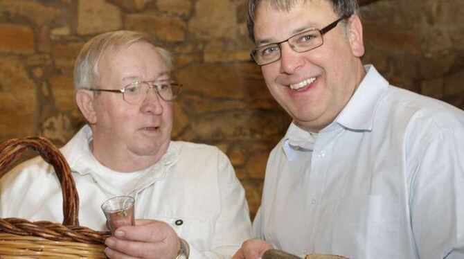 Jürgen Fritz und Thomas Keck (Bild rechts, von links) bringen Schlachtplatte und Schnaps unter die Leute - junge wie ältere.