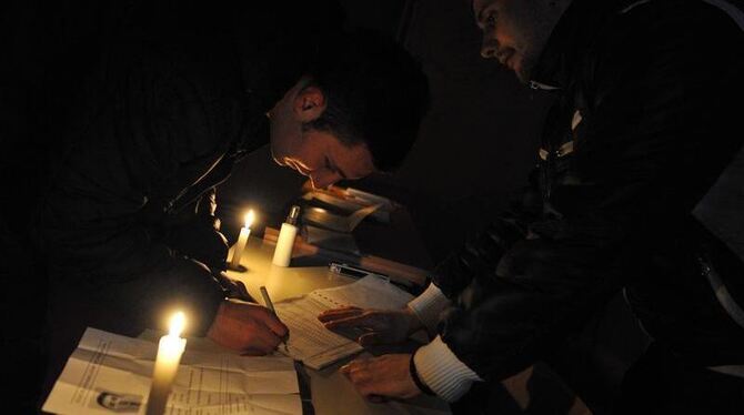 Bei Kerzenschein nimmt ein Serbe am Referendum teil. Foto: STR
