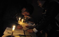 Bei Kerzenschein nimmt ein Serbe am Referendum teil. Foto: STR