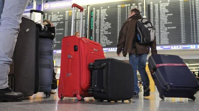 Flugreisende stehen im Terminal 1 des Flughafens von Frankfurt am Main vor einer Anzeigetafel mit den Abfluginformationen. Fo