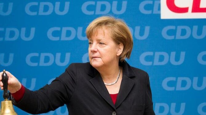 Bundeskanzlerin Angela Merkel läutet  vor Beginn einer Sitzung des CDU Bundesvorstands mit der Glocke. Foto: Michael Kappeler