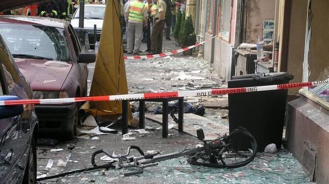 Glasscherben liegen am 09.06.2004 vor einem durch eine Explosion zerstörten Haus in Köln. Auch dieser Anschlag, bei dem vor sieb