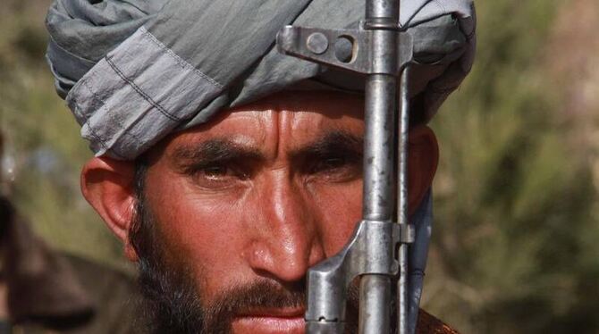 Ein Taliban legt im Rahmen eines Amnestieprogramms seine Waffe nieder. Trotz solcher Programme geht der Krieg in Afghanistan