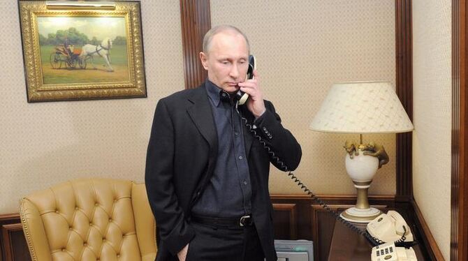 Wladimir Putin telefoniert in seiner Wahlkampf-Zentrale in Moskau. Foto: Alexey Drughinyn