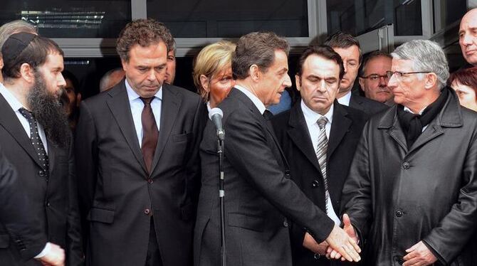 Frankreichs Staatspräsident Sarkozy teilt dem Vertreter der jüdischen Gemeinde Frankreichs vor der Schule in Toulouse seine Ante