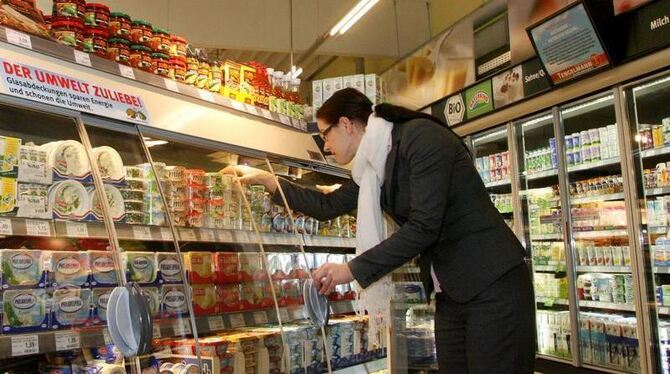 Eine Testkäuferin schaut sich ein Produkt aus dem Kühlregal an. Verbraucher haben oft Probleme, sich ein klares Bild vom Preis e