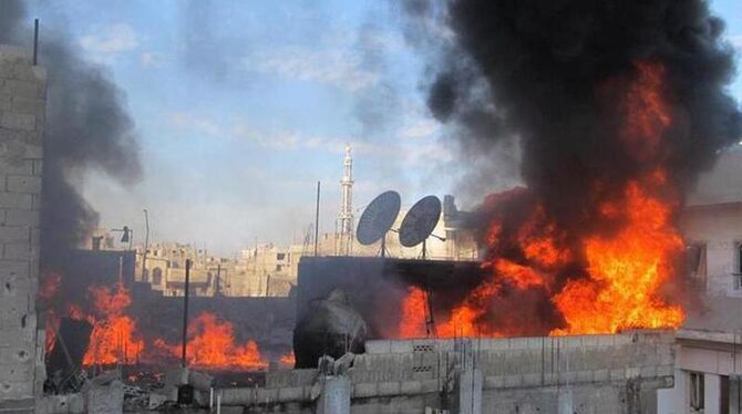 Brennende Häuser in der Protesthochburg Homs. Foto: LCC/Archiv