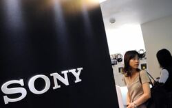 Besucher stehen neben dem Sony-Logo auf einem Messestand in Tokio. Foto: Franck Robichon/Archiv