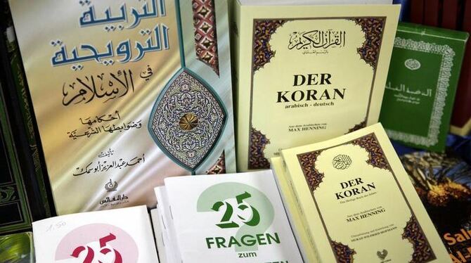 Eine deutschsprachige Ausgabe des Koran und weitere religiöse Schriften. Foto: Peer Grimm/Archiv