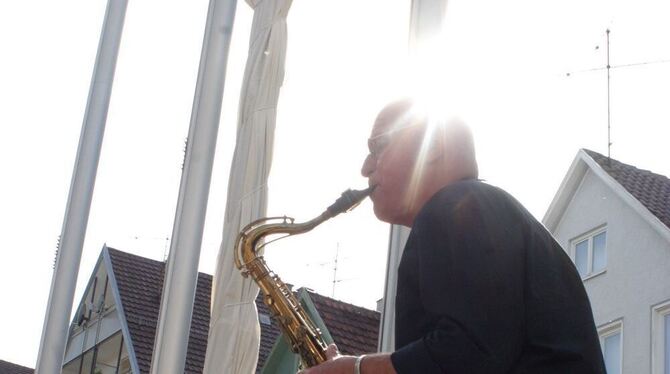 Wolfgang Weiler umrahmt mit dem Saxofon die Einweihung der Schneckenstele, die hier noch verhüllt zu sehen ist. Foto: Knauer