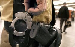 Ein Polizeibeamter trägt Handschellen und seine Dienstwaffe am Hosenbund. Foto: Norbert Försterling/Archiv