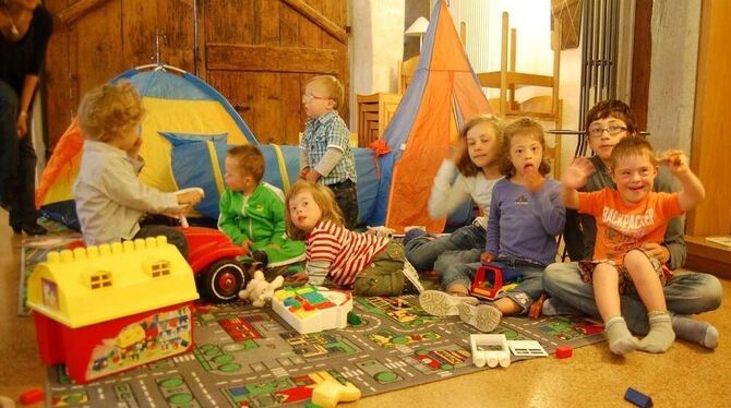 Down-Syndrom-Kinder spielen im Klosterhof in Metzingen mit ihren Geschwistern, während ihre Eltern bei Kaffee und Kuchen Erfahru