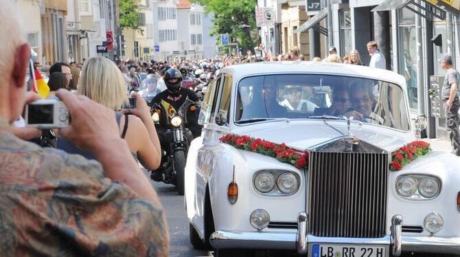 Schaulustige fotografieren nach der Trauung des örtlichen Hells Angels-Chefs das Brautauto, das durch Reutlingen fährt. Foto: