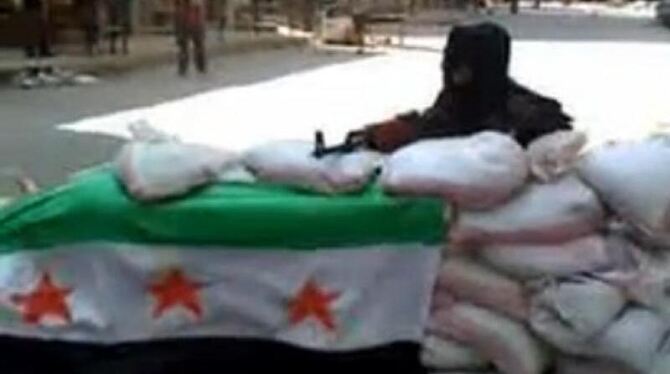 Der Ausschnitt aus einem Video Ugarit News vzeigt einen bewaffneten Mann hinter Sandsäcken in Aleppo. Foto: Ugarit News (ACHT