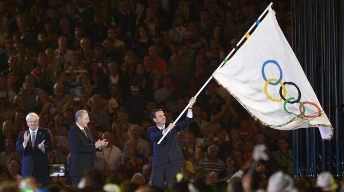 Eduardo Paes, Bürgermeister von Rio de Janeiro, schwenkt die olympische Fahne. Foto: Christophe Karaba