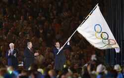 Eduardo Paes, Bürgermeister von Rio de Janeiro, schwenkt die olympische Fahne. Foto: Christophe Karaba