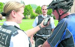 Die beiden Polizeibeamten Kai-Nils Reinhard und Isabell Volz bei der (gestellten) Überprüfung eines Fahrradfahrers. GEA-FOTO: DÖ