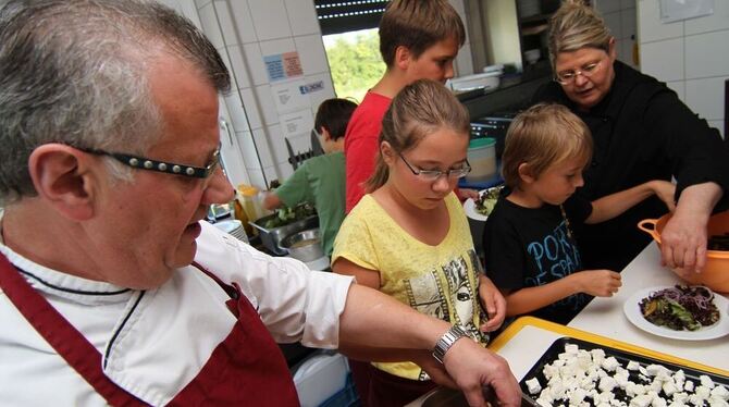 Edwin und Marion Bosler von der Stadiongaststätte des SV Hülben zeigen den Kindern, wie man einen schicken Pflaumen-Käse-Salat m
