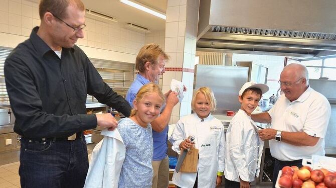 Die ersten Miniköche der Freien Evangelischen Schule werden ausgestattet von Stefan Creuzberger (links), Gerhard Mayer (Mitte) u