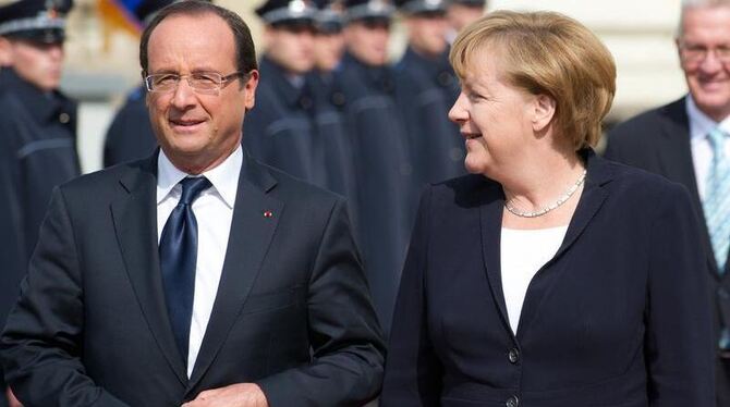 Bundeskanzlerin Angela Merkel und der französische Staatspräsident Francois Hollande unterhalten sich vor dem Barockschloss i