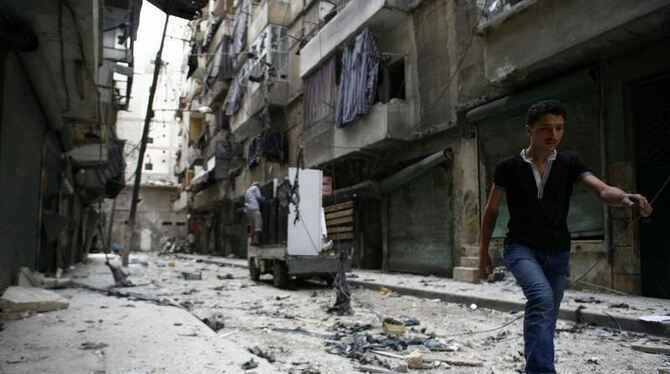 Syrer verlassen das von den Anschlägen zerstörte Gebiet in Aleppo. Foto: Carlos Palma