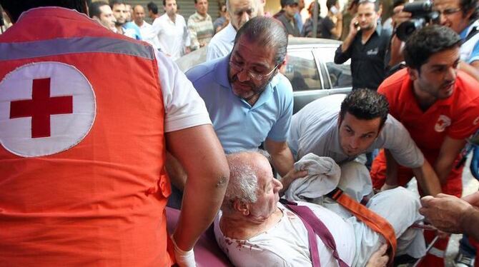 Mitarbeiter des libanesischen Roten Kreuzes helfen einem Verletzten. Foto: Nabil Mounzer