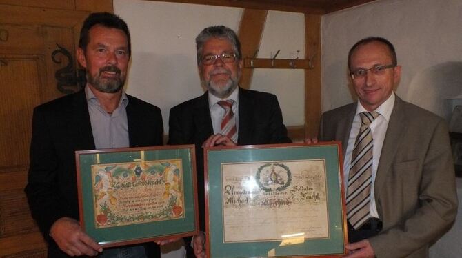 Helmut Schepper (von links), Eberhard Wolf und sein Bürgermeister-Kollege aus Metzingen, Dietmar Bez, mit den auf die Alb zurückgekehrten Urkunden. FOTO: WURSTER Helmut Schepper (von links), Eberhard Wolf und sein Bürgermeister-Kollege aus Metzingen, Dietmar Bez, mit den auf die Alb zurückgekehrten Urkunden. FOTO: WURSTER
