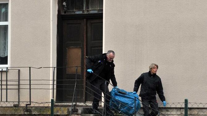 Beamte der Spurensicherung tragen am 30.10.2012 in Otterstedt (Thüringen) ein Beweisstück aus einem Wohnhaus. Foto: Martin Sc