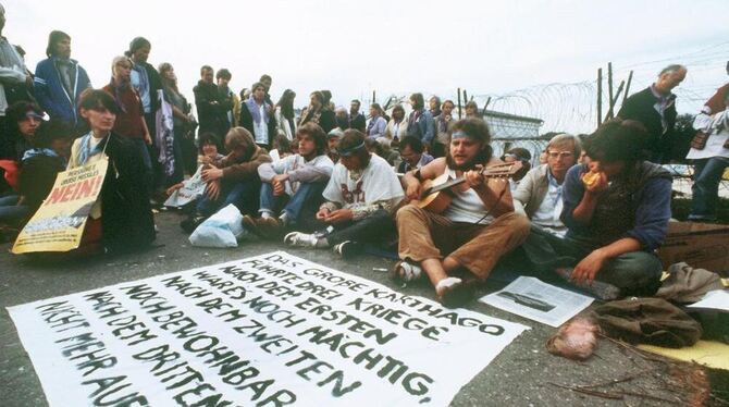 Demonstranten mit einem auf dem Boden ausgebreitetem Transparent sitzen 1983 in Mutlangen vor einer der Zufahrten zum Atomwaffen