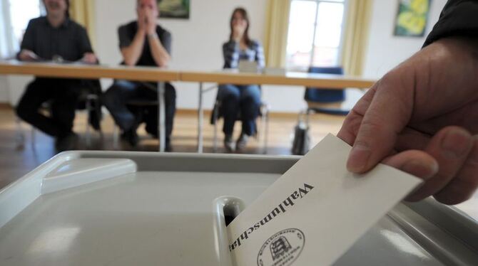 Eine Hand wirft am 27.11.2011 im Rathaus in Sigmaringen (Baden-Württemberg) den Wahlumschlag zum Volksentscheid über das Projekt
