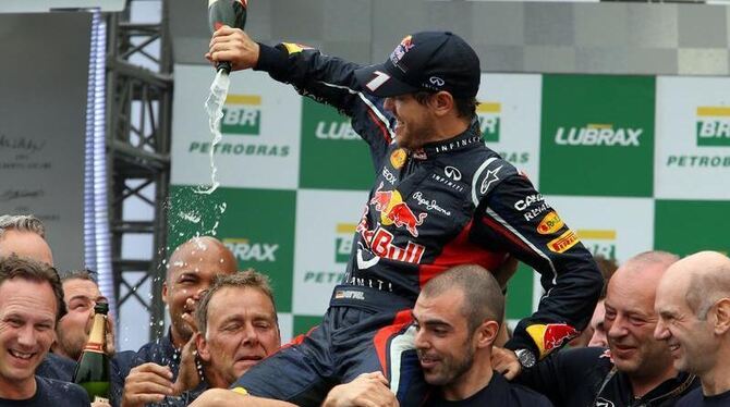 Sebastian Vettel und die Red-Bull-Crew feiern den dritten WM-Titel mit ganz viel Champagner. Foto: Jens Büttner
