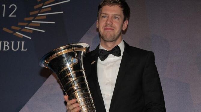 Endlich hält Sebastian Vettel den WM-Pokal in seinen Händen. Foto: Epa