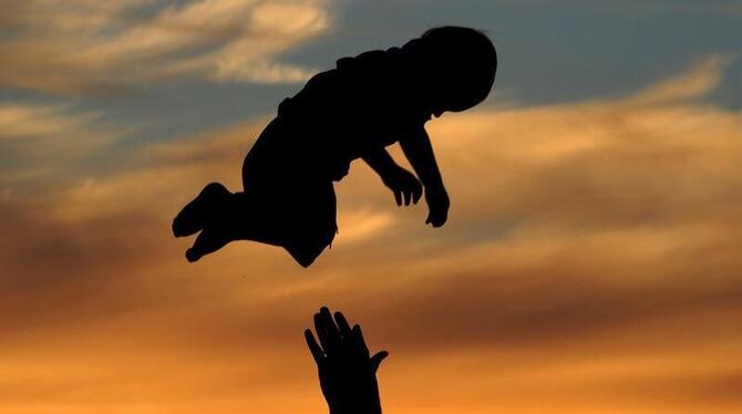 Ein Vater spielt am Ostseestrand von Noer (Kreis Rendsburg-Eckernförde) mit seinem Sohn. Foto: Julian Stratenschulte/Archiv