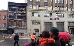 Passanten stehen vor einer eingestürzten Hausfassade in Lower Manhattan, New York. Wirbelsturm «Sandy» hat enorme Schäden ang