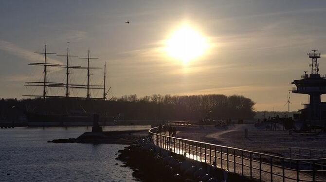 Spaziergänger genießen in Lübeck am Ufer der Ostsee die Nachmittagssonne. Foto: Alkimos Sartoros