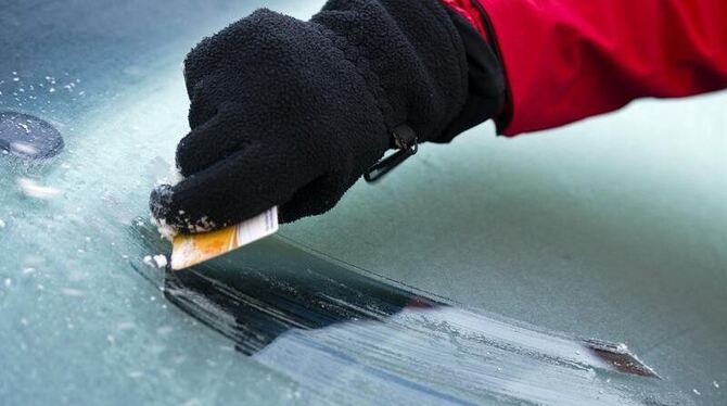 Eiskratzen: Ein Frau kratzt Eis von der Frontscheibe ihres Autos. Ein Hoch soll nun milde Luft nach Deutschland bringen. Foto