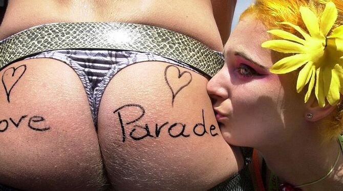 »Love Parade« steht auf den nackten Po, den eine Raverin in Berlin küsst. Foto: Stephanie Pilick/Archiv