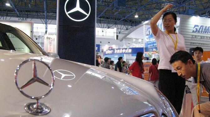 Besucher betrachten auf der International High Technology Expo in Peking, China eine Mercedes E-Klasse. Foto: Adrian Bradshaw
