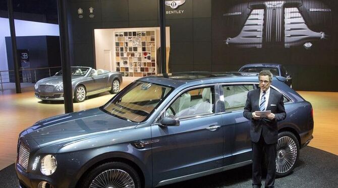 Der damalige Bentley-Chef Wolfgang Dürheimer steht bei der Auto China 2012 neben einem Bentley Geländewagen als Konzeptfahrze
