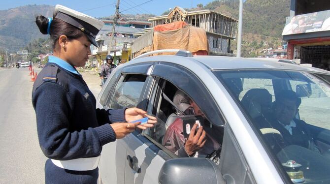 Die Polizistin Shanta Chettri kontrolliert in Pokhara die Papiere eines Autofahrers. FOTO: DPA
