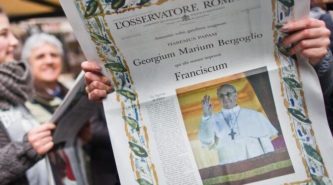 Eine junge Frau liest am Vatikan in der Vatikan-Zeitung »L'Osservatore Romano« die in einer Sonderausgabe über den neu gewähl