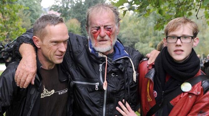 Am »schwarzen Donnerstag« stützen zwei Männer im Stuttgarter Schlossgarten einen schwer verletzten Mann. Foto: Marijan Murat/