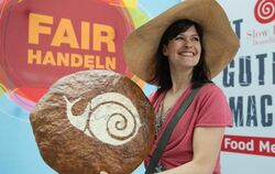 Modell Katrin hält während eines Fototermins ein Brot mit dem Logo der Organisation Slow Food in den Händen, im Hintergrund steh